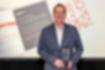 Bryant Smith holding his EDPA award in front of an image of Storylink Creative branding