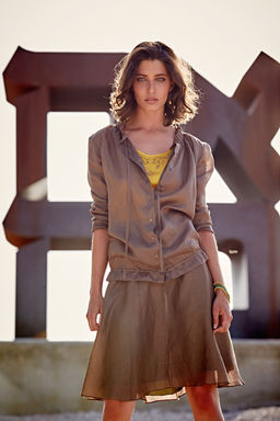 דוגמנית לובשת חליפת חצאית חומה של משכית על רקע פסל אהבה במוזיאון ישראל