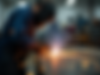 Action-shot of a welder using a gas torch, sparks flying, professional workshop setting, n