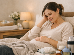 Mom resting during postpartum recovery with newborn nearby