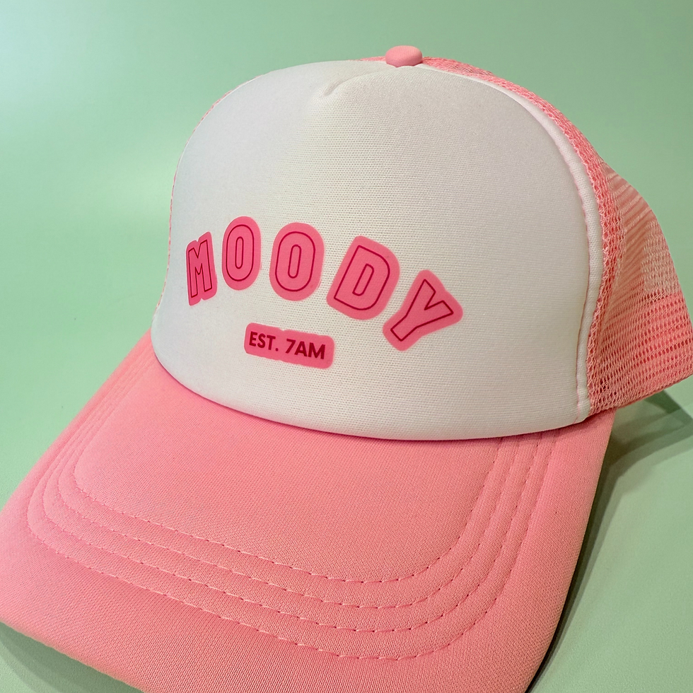 white and pink trucker cap with a logo on the front saying "moody since 7am"