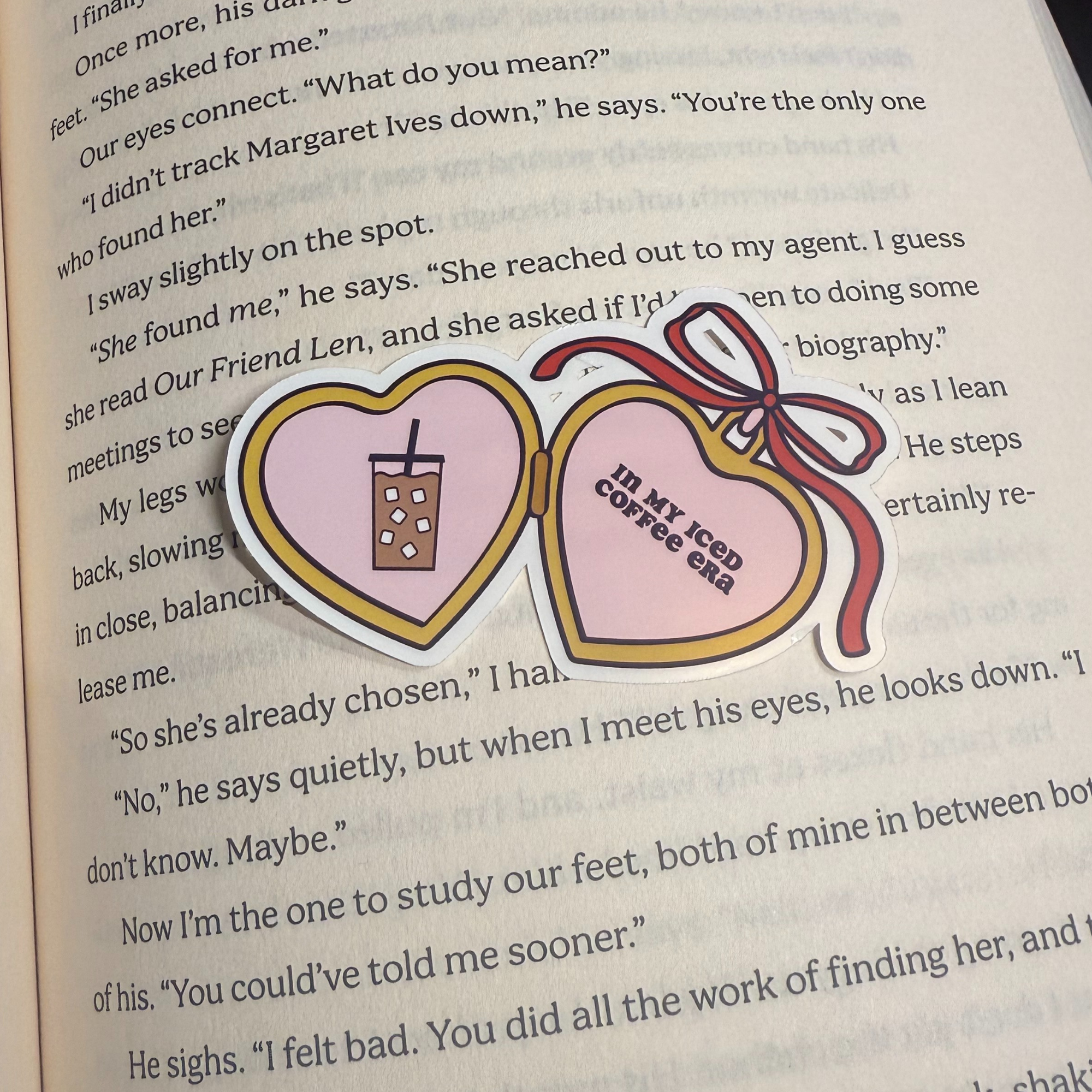 heart locket shaped sticker with a coffee in one side and text : in my iced coffee era" on the other side
