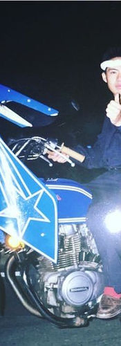 Zwei Personen auf einem auffällig modifizierten, blau-weißen Motorrad im japanischen Bosozoku-Stil bei Nacht.