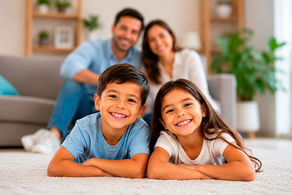 Família feliz. Primer plano niños y segundo plano padres.