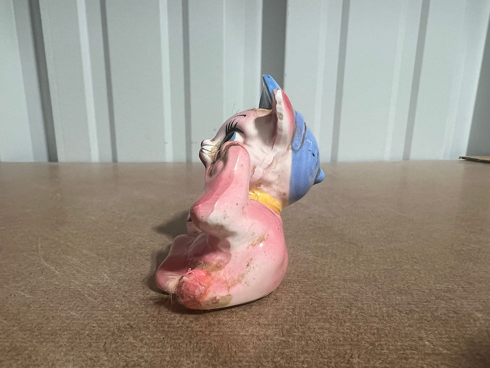 Thumbnail: Vintage Japanese ceramic pink cat. laying on back wearing a black and blue cap w