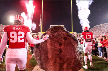 Picture of players walking out on the field touching Hep's Rock (courtesy of Indiana University Athletics)