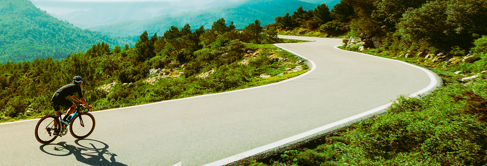 acyclist-riding-bike-sunset-mountain-road.png