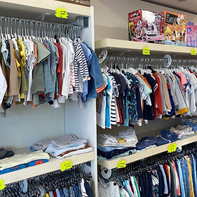 Un rayon de la boutique avec des vêtements sur ceintre pour les garçons et les filles