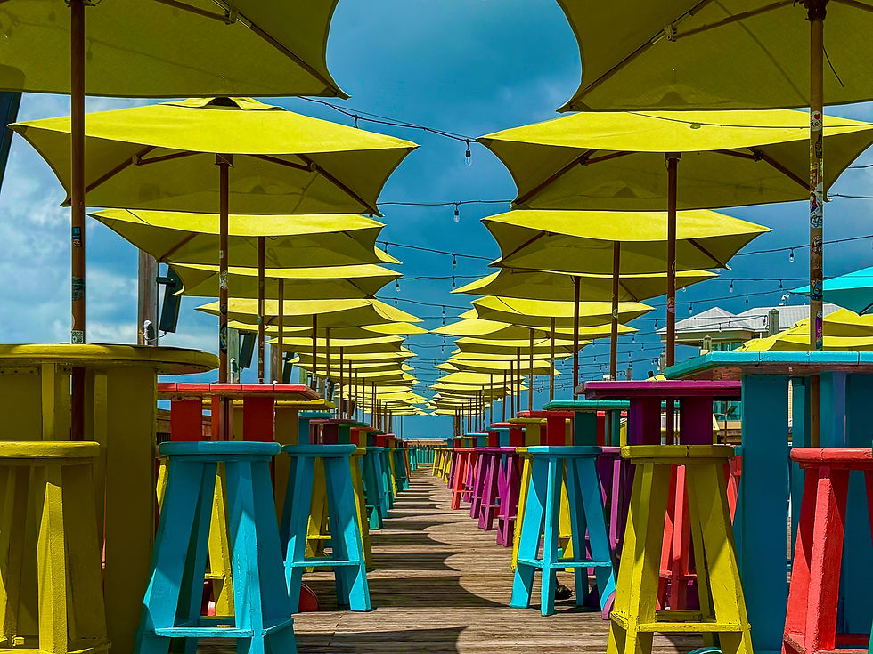 Key West Sunset Pier colorful table yellow umbrellas with a cloudy sky storms rolling in