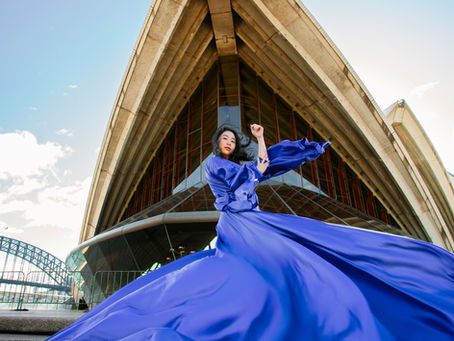 Couple photographed at the Sydney Opera House with the Harbour Bridge behind them on a pre-wedding shoot