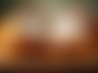 An open antique book with ornate floral borders and yellowed pages sits on a wooden table, conveying a sense of history and artistry.