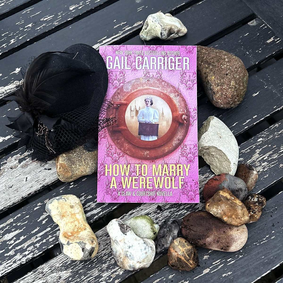 the book How to Marry a Werewolf by Gail Carriger surrounded by rocks and wearing a tiny top hat