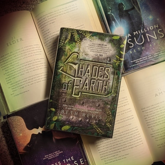 Shades of Earth book with Across the Universe and A Million Suns on top of open books with text visible