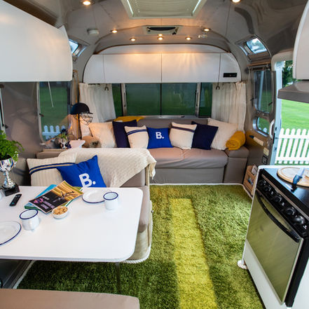 Looking inside the airstream towards the sofa, seeing the appliances and cricket touches