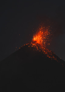 A volcano with lava erupting from the top.