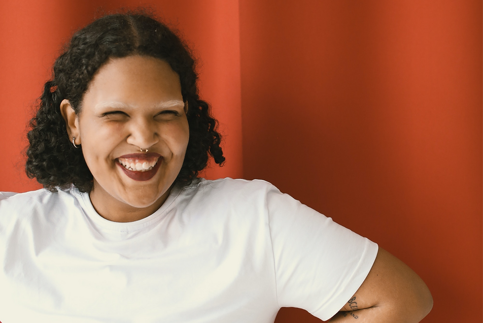 A woman smiling at an LGBTQ+ training programme.