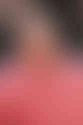 A photo of Chris McDonnell, a Queer man with pale skin, short brown hair and a goatee. He wears a pink polo shirt and black glasses.