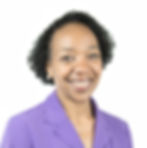 A photo of Donna Bellamy, an ERG member at Omnicom. She has dark skin and short textured hair. She wears a purple suit jacket and pearl earrings.