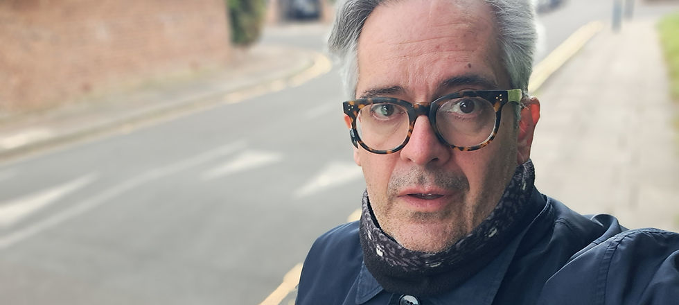 Man in glasses with road behind.