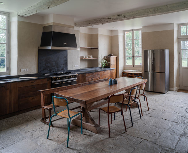 Architecte patrimoine Versailles restauration châteaux : cuisine château Biscay Pays Basque, plan travail pierre, meubles bois massif, grande table manger bois, piano cuisson, frigo américain, menuiseries simple vitrage, volets intérieurs - Cabinet architecture Antoine de Gironde Versailles 750m Château expert secteur sauvegardé ABF