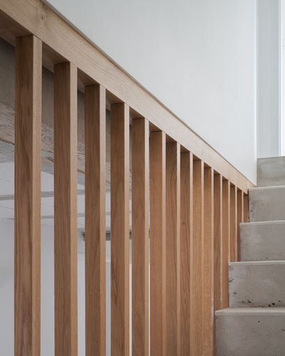 Architecte Versailles garde-corps lamelles bois verticales escalier sous-sol Bougival : menuiserie bois sur mesure, lamelles verticales espacées, escalier béton brut, murs blanc lumineux - Cabinet Antoine de Gironde 10 rue Fontenay