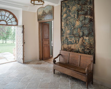 Architecte patrimoine Versailles restauration châteaux secteur sauvegardé : hall entrée château Biscay Pays Basque rénovation intérieure, pierre naturelle sol, tapisserie murale ancienne conservée, banc bois massif, porte ancienne bois sculptée, chauffage sol, murs pierre crème - Cabinet Antoine de Gironde 10 rue Fontenay Versailles collaboration ABF