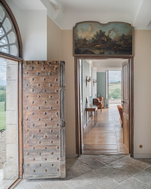Cabinet architecture Versailles restauration châteaux patrimoine : entrée château Biscay Pays Basque, porte ancienne bois sculptée conservée, quincaillerie origine, chauffage sol, sol pierre naturelle, murs pierre crème, lumineux - Antoine de Gironde 10 rue Fontenay Versailles architecte expert Monuments Historiques collaboration ABF