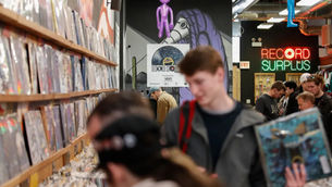 Customers searching through crates of vinyl records in a music store.