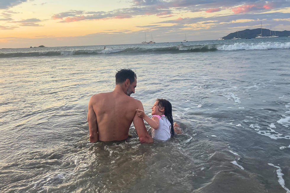 Dad and daughter sitting in the ocean