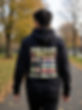 Man walks away wearing a black hoodie with printed text on the back.
