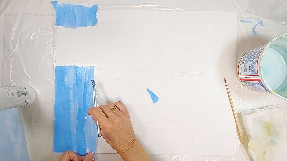 Collaging with blue paper for sky