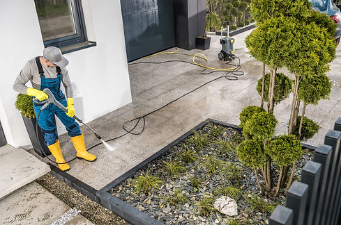 Caucasian Men Pressure Washing House Surrounding Concrete Elements. Cleaning Paths and Dri