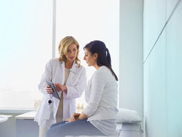 Kuvitauskuvassa lääkäri ja potilas keskustavat vastaanotolla.