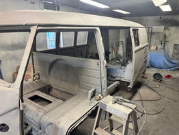 VW 1967 microbus restoration in progress, showing body panels, workshop setting.
