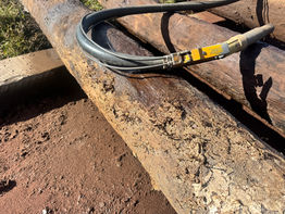 Close-up of textured rusty pipes with a black hose Adelaide Sandblasting