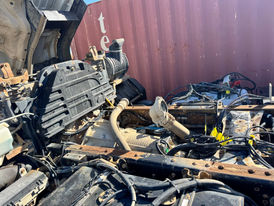 Close-up of truck engine parts with a shipping container background.