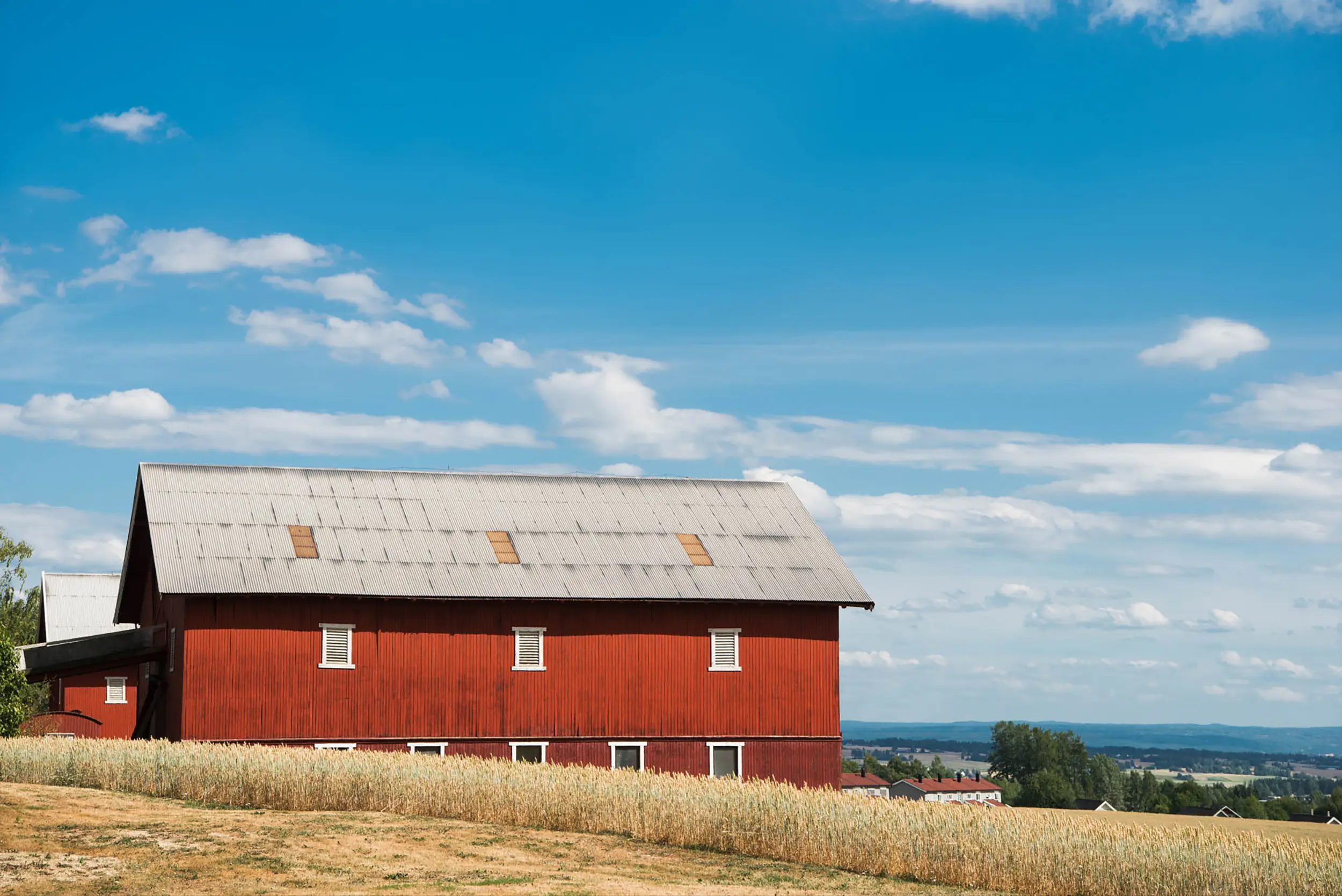 a red farm under a cloudly sky