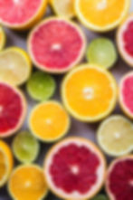 Citrus fruits cut in half with an array of colors by Bruna Branco