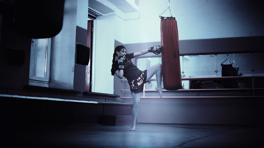 woman punching red heavy bag