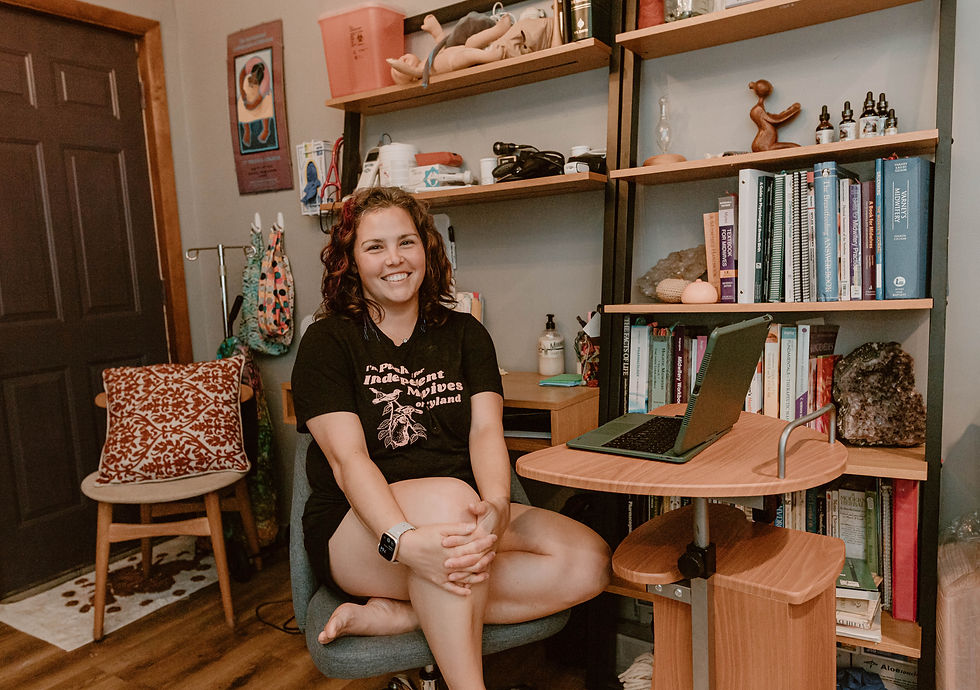 Monika Karosman, CPM, primary homebirth midwife at Althea Midwifery in her home office in Berlin, MD. She is smiling wearing an "I'm pushing for independent midwives of Maryland" t shirt.