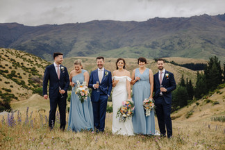 Wedding party in vineyard with Central Otago Mountains behind. Bride groom 2 x bridesmaids in light blue, 2 x groomsmen in navy