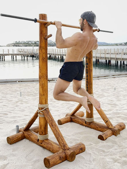 TimberJacked masif ahşap squat rack ile açık havada barfiks yapan erkek sporcu