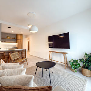 Living area with linear kitchen lighting and pendant lamps, providing warm task and accent illumination.