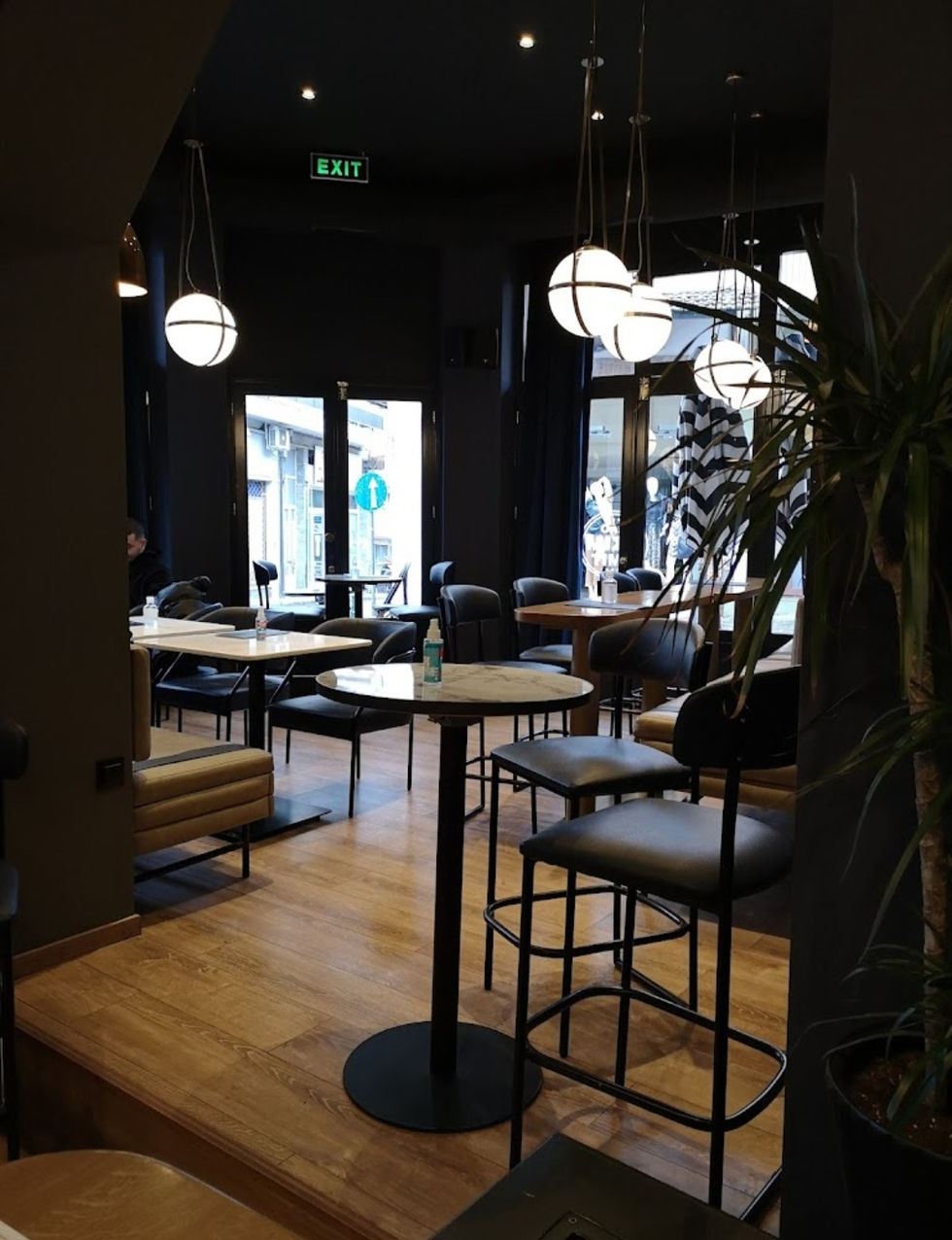 Bar and restaurant seating with suspended globe pendant lights and dark ceiling creating intimate ambiance.