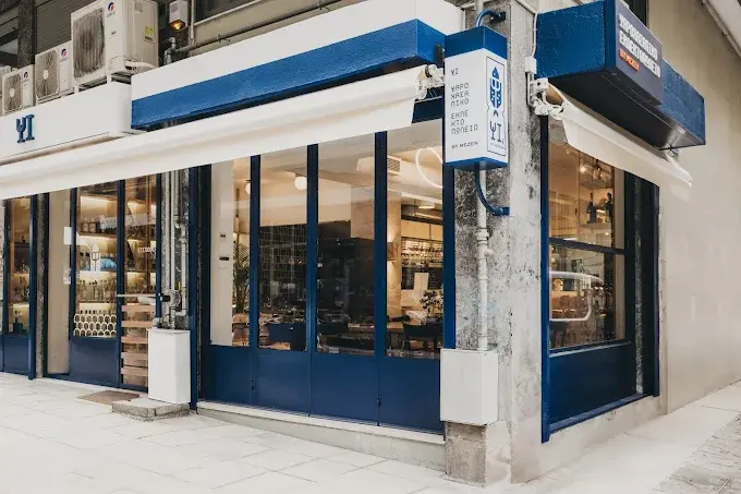 Exterior façade with blue storefront and illuminated signage.