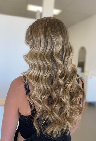 woman with blonde curled hair facing away from the camera