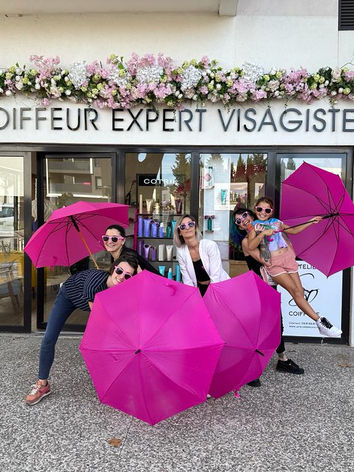 Sofia et l'équipe de son salon avec des parapluies roses pour Octobre Rose 2023
