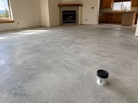 Radon test kit placed on an exposed concrete slab after flooring removal in a Central Oregon home