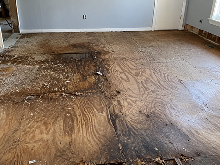 Water-damaged subfloor exposed during flooring removal in a Central Oregon home