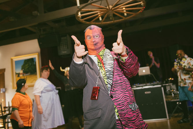 Man in Two-Face costume pointing at a Halloween party
